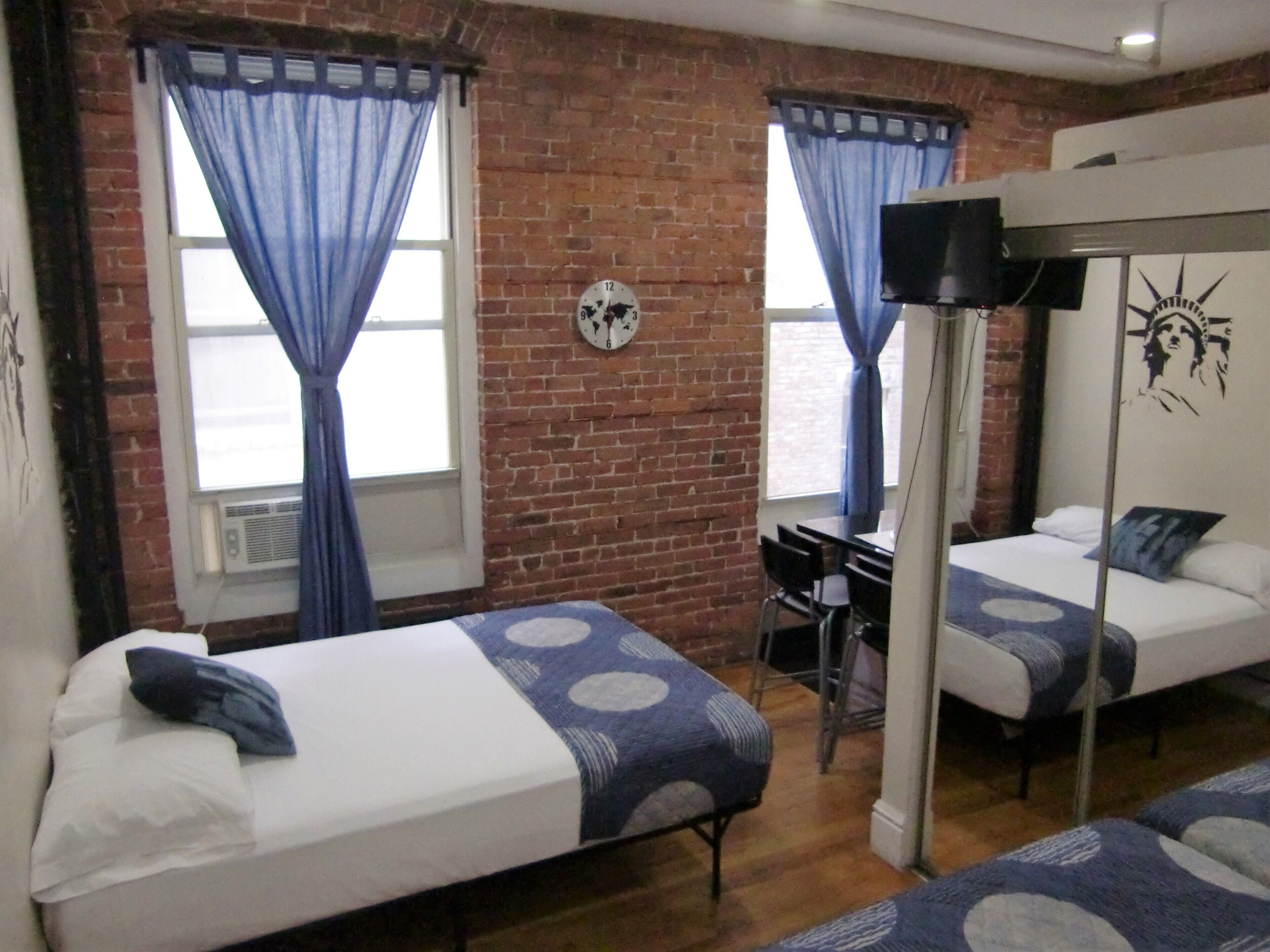 A room with two beds, a desk, and a TV.