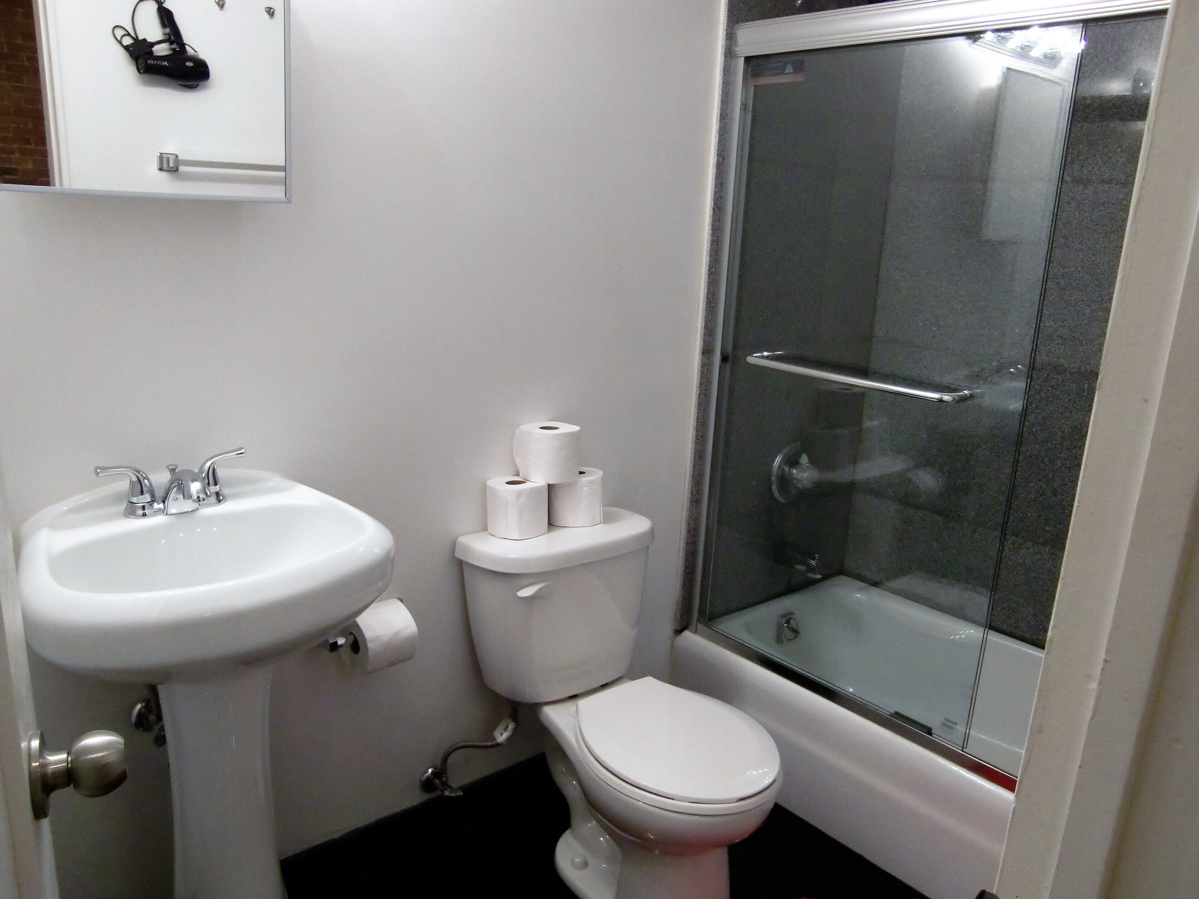 A bathroom with a sink, toilet, and glass-enclosed shower.