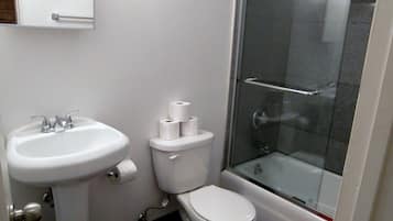 A bathroom with a sink, toilet, and glass-enclosed shower.