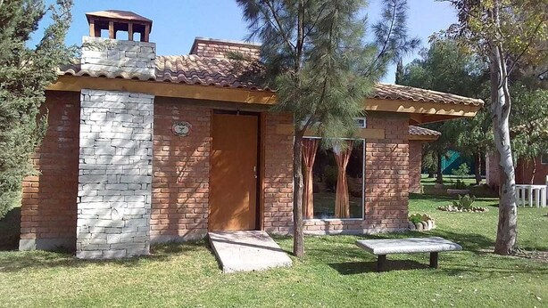 A small brick building with a stone facade, a wooden door, and a small porch. - 15  cabins in and Exclusive and private area inside the  Valladolid Acuatic Park (Aguascalientes)