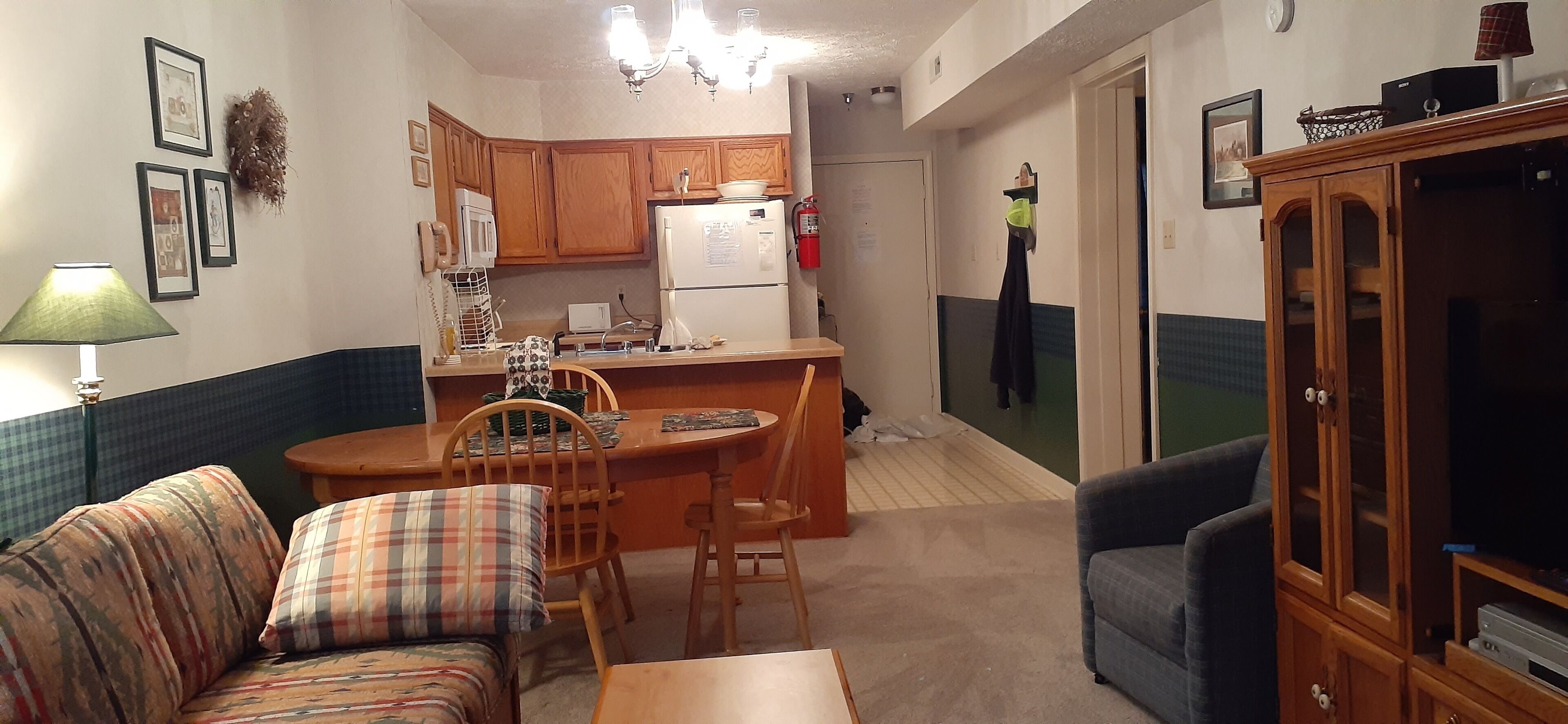 A compact living space with a kitchenette, a dining area, and a seating area.