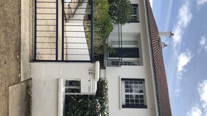 A two-story building with a white facade, black window frames, and a tiled roof.