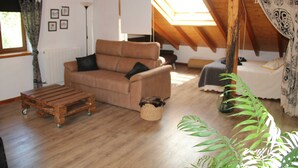 A cozy living room with a wooden ceiling, a sofa, a coffee table, and a plant. - Chalet House Honorato San Rafael routes of (San Rafael)