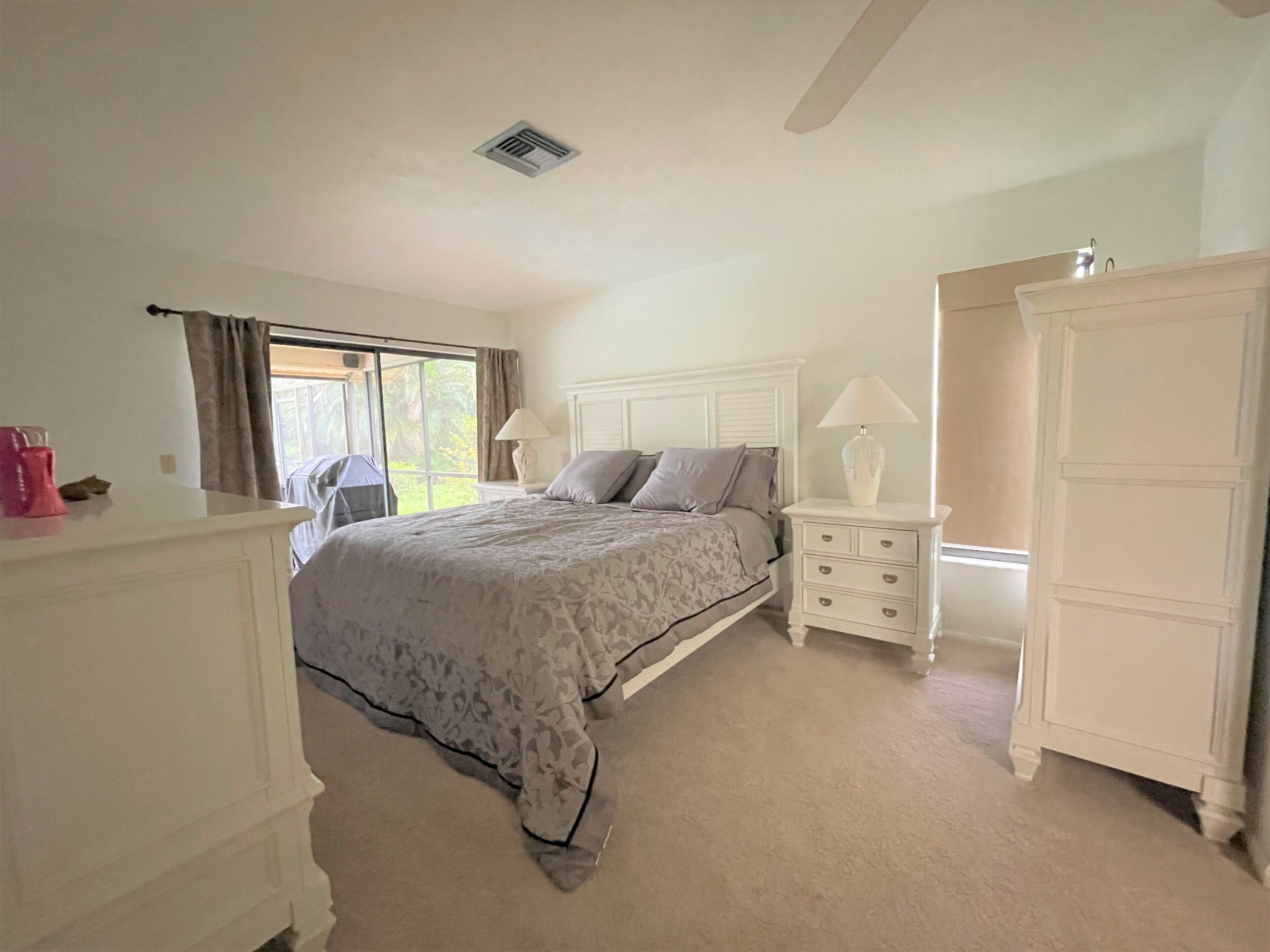 A bedroom with a bed, nightstands, a dresser, and a wardrobe.