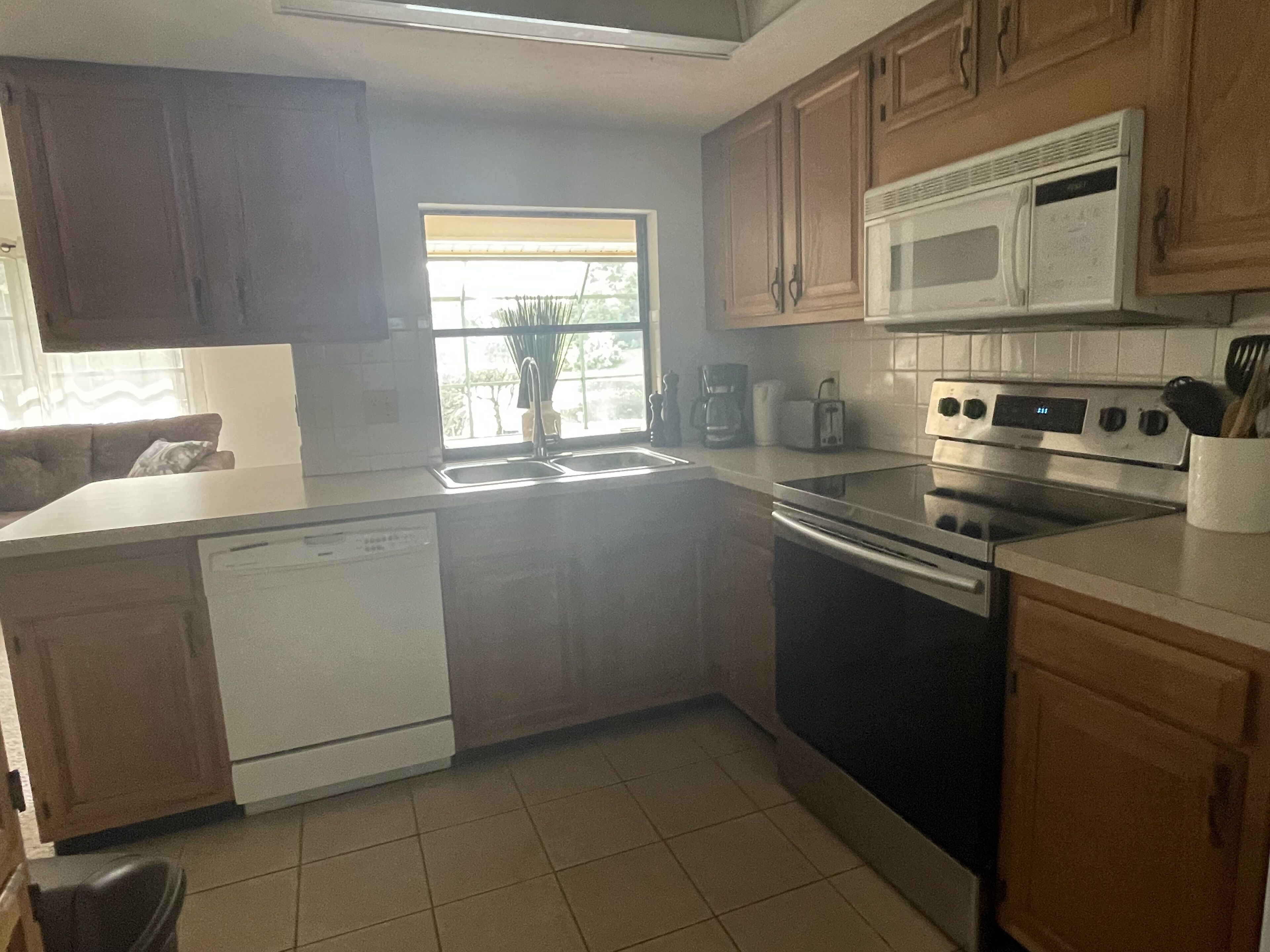 A kitchen with wooden cabinets, a microwave, a stove, and a dishwasher.