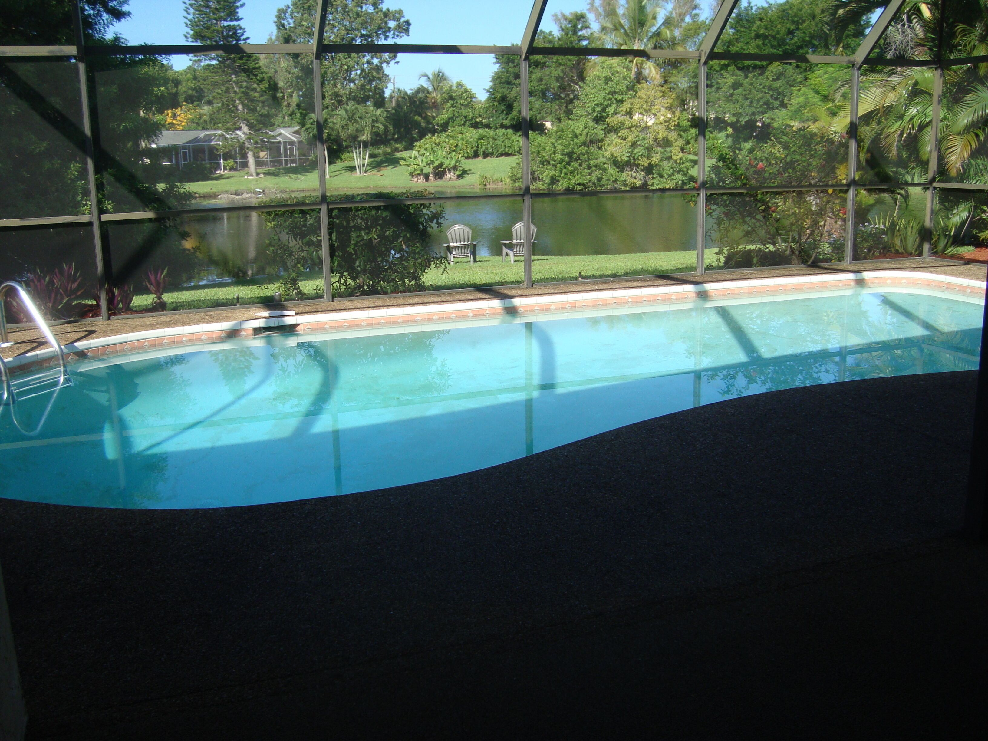 Une piscine avec vue sur un lac et des arbres.