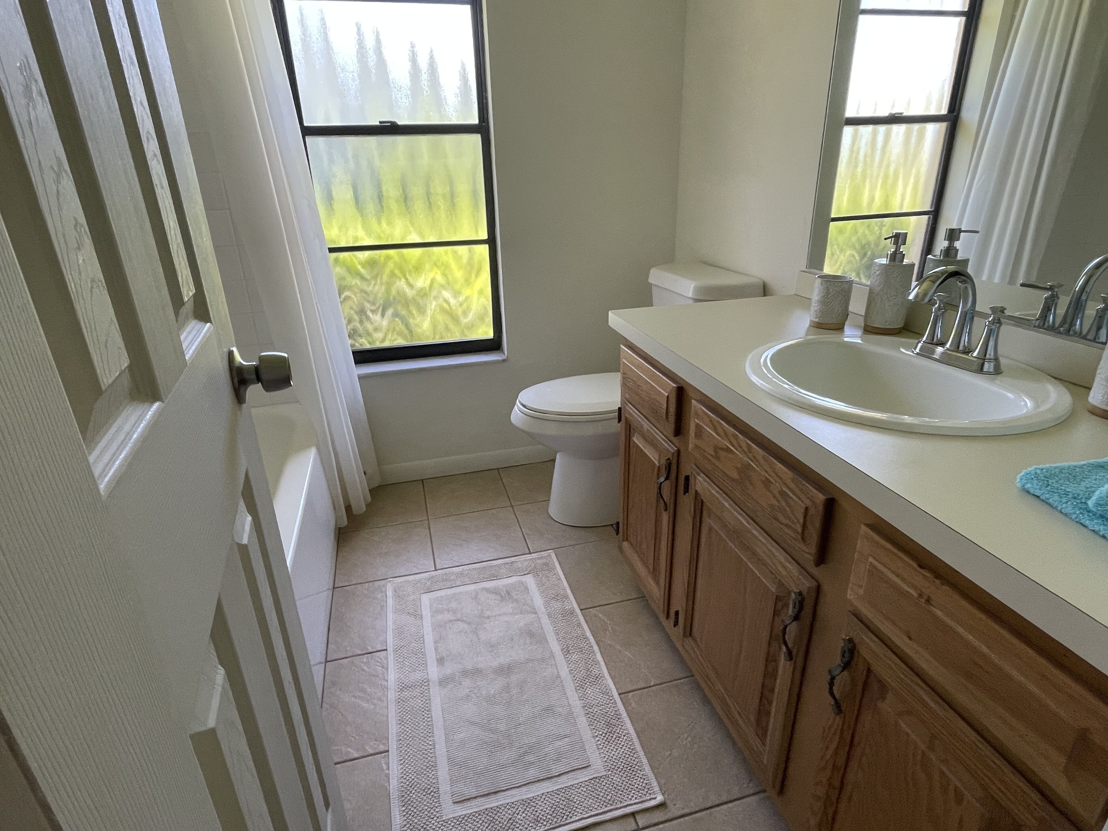 Un baño con inodoro, lavamanos y ventana.