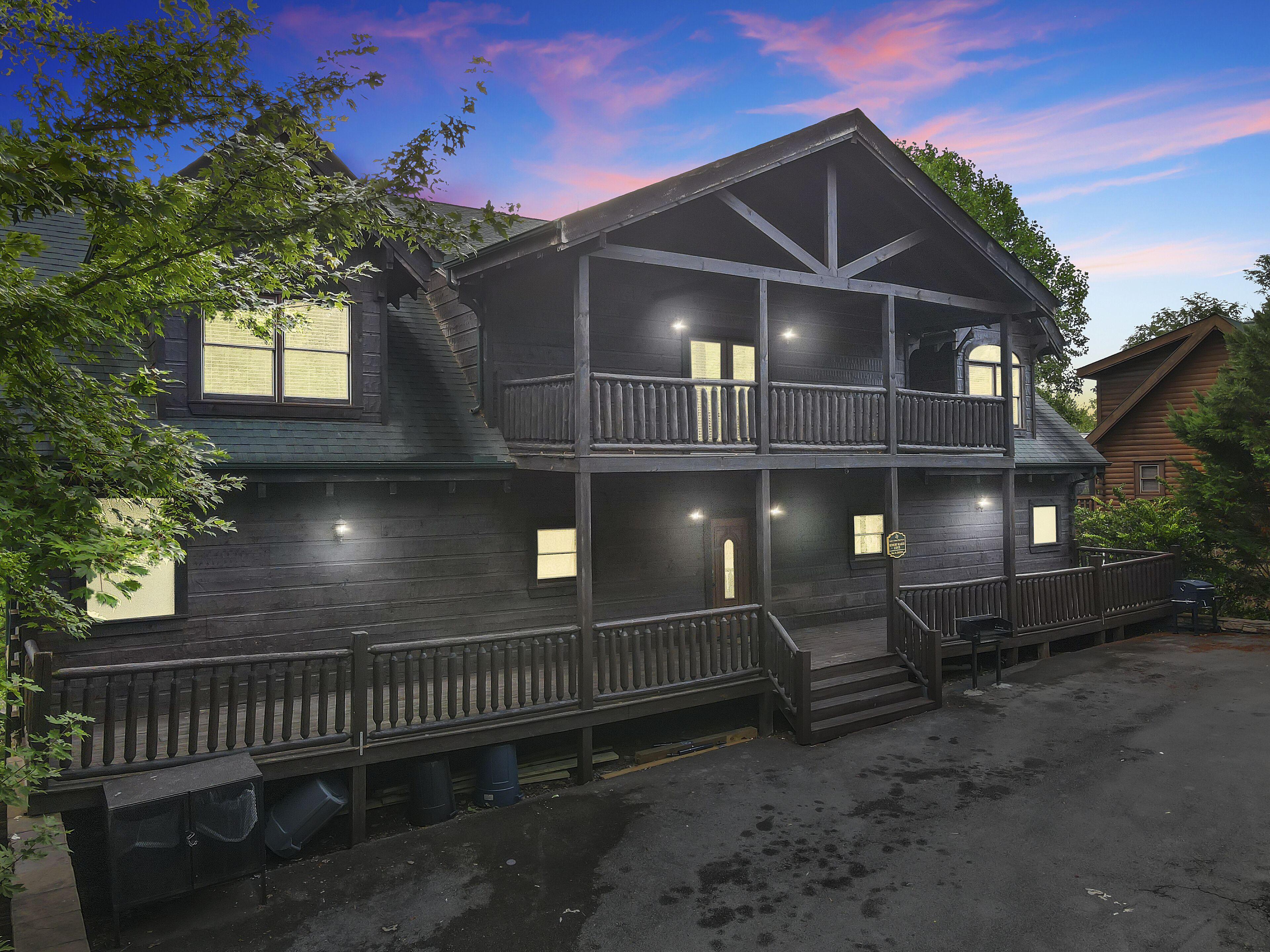 Een houten huis met twee verdiepingen, een balkon, een veranda en een garage.