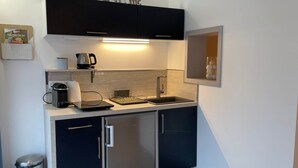 A compact kitchenette with a coffee machine, kettle, and a small sink. - Studio Anemone: self-catering cottage in Sarlat with private heated pool (Sarlat-la-Canéda)
