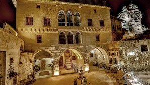 Un edifici històric amb galeries en arc, una escala central i zones d'estar a l'aire lliure.