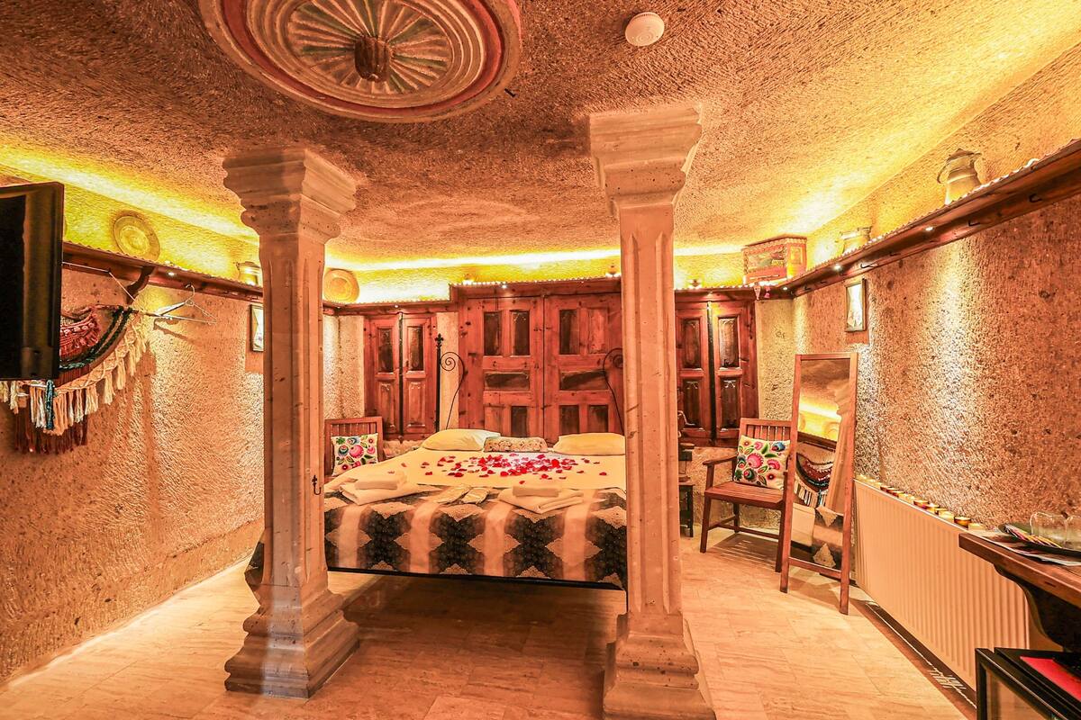 Ein traditionell eingerichteter Raum mit Bett, Holzmöbeln und einer strukturierten Decke.