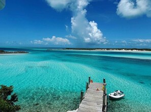 A wooden pier leading to a boat docked in clear turquoise waters. - Luxury Catamaran Sailing Trips in the Exumas & Staniel Cay area (Staniel Cay)
