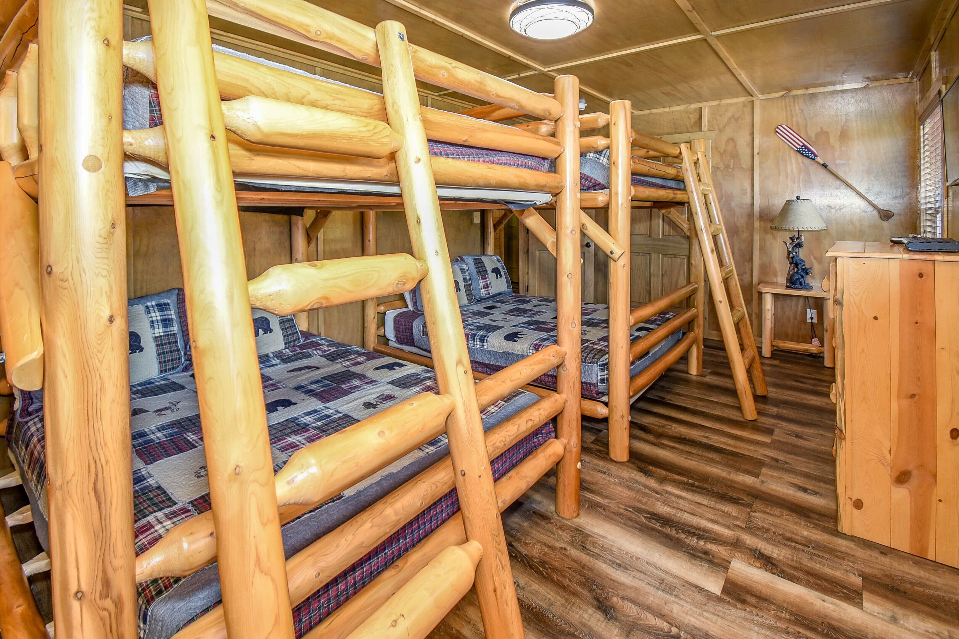 Eine Holzhütte mit Etagenbetten, einem kleinen Schreibtisch und einer Lampe.