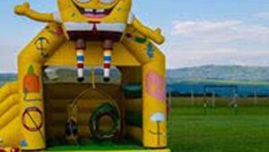 A large inflatable play structure shaped like a cartoon character with a slide and a tunnel. - Dayton Hotel (Nakuru)