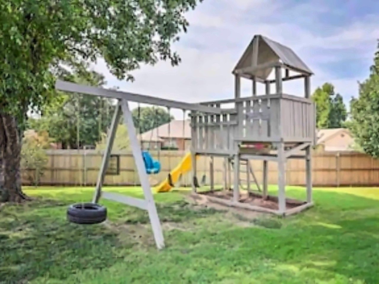 Un parque infantil con columpios y un tobogán.