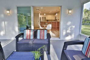A patio with wicker furniture, a small table, and a potted plant. - SASSA Boutique Homes (Homosassa)