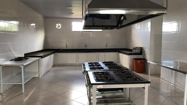 Una cocina amplia con una cocina a gas grande, electrodomésticos de acero inoxidable y gran espacio de encimera.