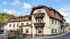 A traditional European-style building with multiple balconies, a brick facade, and a red-tiled roof.