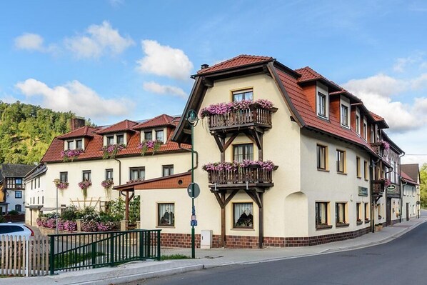Ein traditionelles Gebäude im europäischen Stil mit mehreren Balkonen, einer Ziegel-Fassade und einem roten Ziegeldach.
