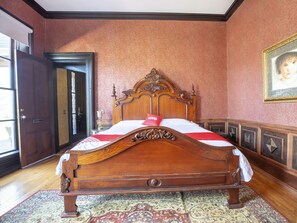 A wooden bed with a headboard, a red and white bedspread, and a patterned rug on a wooden floor. - Falls of Rough Resort (Falls of Rough)