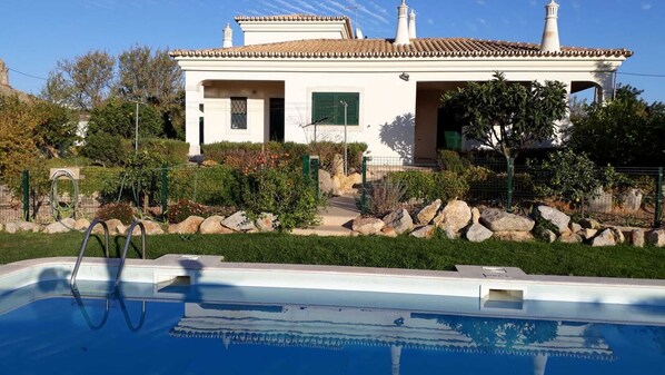 A house with a swimming pool in front.