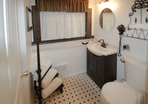 Un baño con inodoro, lavabo y perchero para toallas.