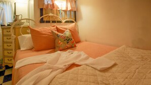 Un dormitorio con cama, almohadas, colcha acolchada, cómoda y espejo.