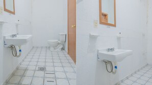 Un baño con inodoro, lavamanos y espejo.