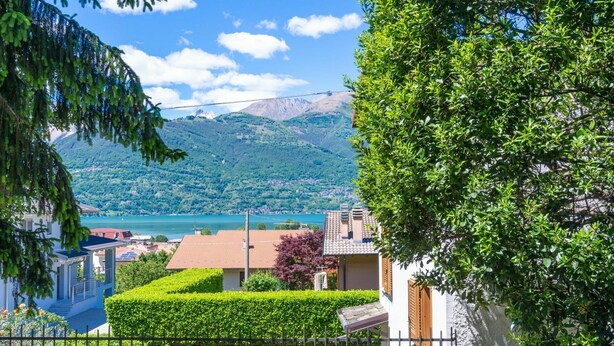 A residential area with houses, a lake, and mountains in the background. - Beautiful apartment for 5 people with hot tub, WIFI, TV, terrace and pets allowed (Colico)