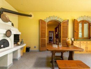 Cuina amb taula de fusta, forlla blanca i paret groga.