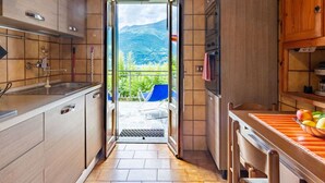 A kitchen with a view of mountains through an open door. - Beautiful private villa for 7 guests with WIFI, TV, terrace and pets allowed (Vestreno)