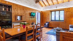 A wooden-paneled room with a dining table, chairs, a television, and a sofa. - Beautiful private villa for 7 guests with WIFI, TV, terrace and pets allowed (Vestreno)