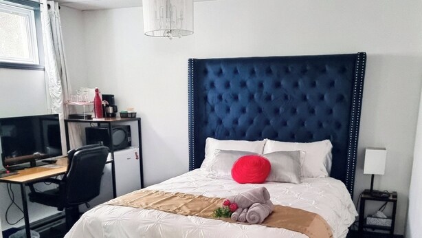 Une chambre d’hôtel bien aménagée, avec un grand lit, un bureau équipé d’un ordinateur et une chaise.