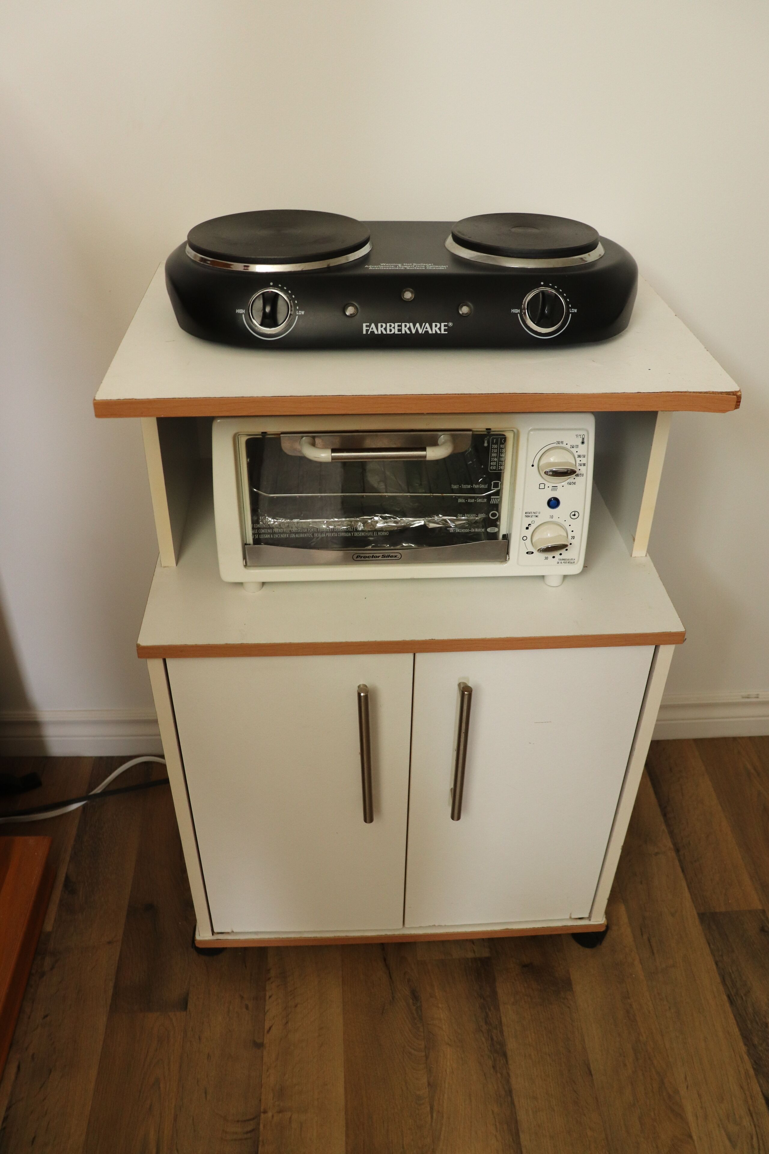 A kitchen with a white cabinet, a black stove, and a white oven.