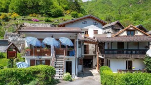 Un hôtel doté d’un escalier central, d’un espace extérieur aménagé avec des parasols et offrant une vue sur les montagnes.