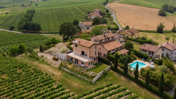 Una finca vinícola con varias construcciones, una piscina y campos en terrazas.