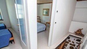 Ein Schlafzimmer mit einem Bett, einem Sessel, einem kleinen Tisch und einem Fenster.