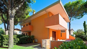 A two-story building with a flat roof and a balcony on the second floor. - Nice apartment for 5 guests with WIFI, A/C, TV, terrace and pets allowed (San Michele Al Tagliamento)