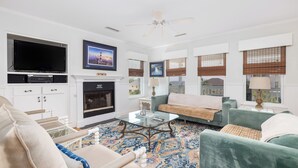 A living room with a television, fireplace, sofa, and coffee table.