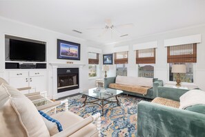A living room with a television, fireplace, sofa, and coffee table.