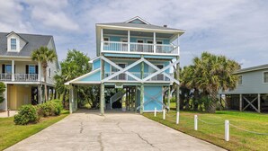 A two-story building with a balcony, a covered entrance, and a staircase leading to the upper level.