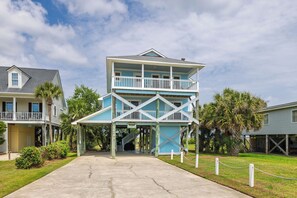 A two-story building with a balcony, a covered entrance, and a staircase leading to the upper level.