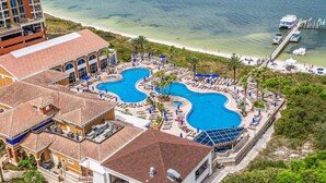 A resort with a large pool area, a beach, and a pier. - Summer is here @ Portofino 2-1409! (Pensacola Beach)