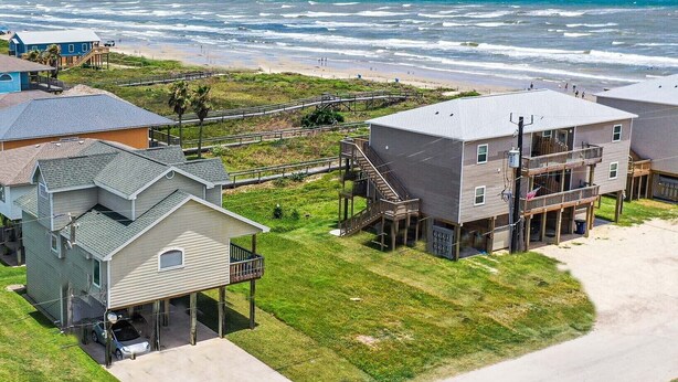 Un área residencial costera con casas, una playa y una vista despejada del océano.