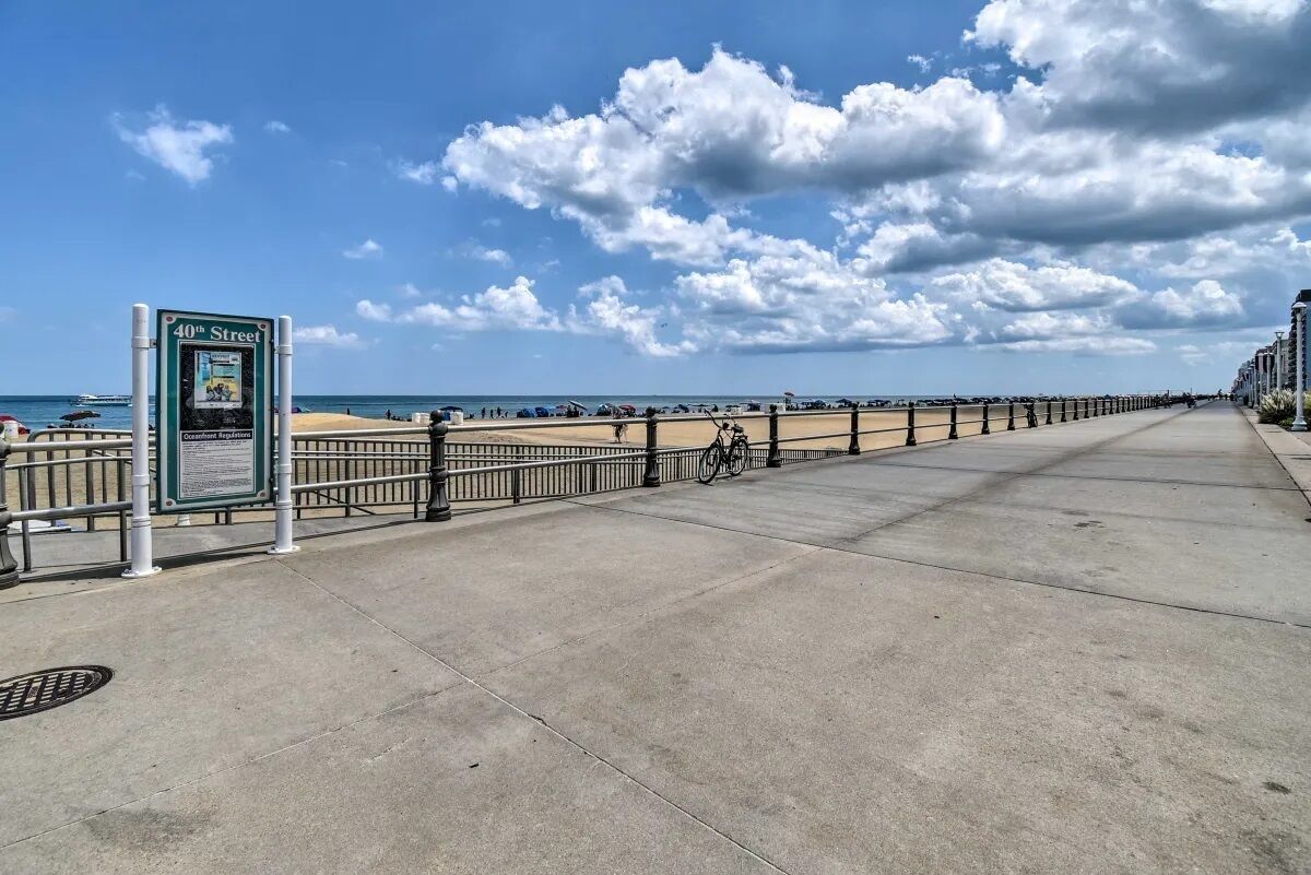 A coastal walkway with a sign for 40th Street, a bike, and a beach in the background.