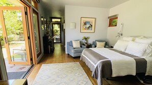 Un dormitorio con cama, sofá, escritorio y un ventanal grande.
