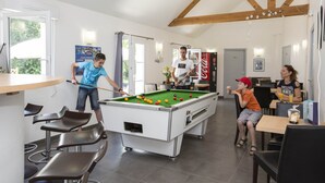A pool table in a room with a wooden ceiling, a Coca-Cola poster, and a Coca-Cola fridge. - Appartement Cosy Equipée |  Accès Piscine (Le Tronchet)