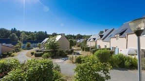 A residential area with houses, a clear sky, and a sunny day. - Appartement Cosy Equipée |  Accès Piscine (Le Tronchet)