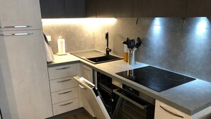 A modern kitchen with a built-in oven, a stovetop, and a dishwasher. - PETITE MAISON: 50 steps from the cable car !!! (Courmayeur)