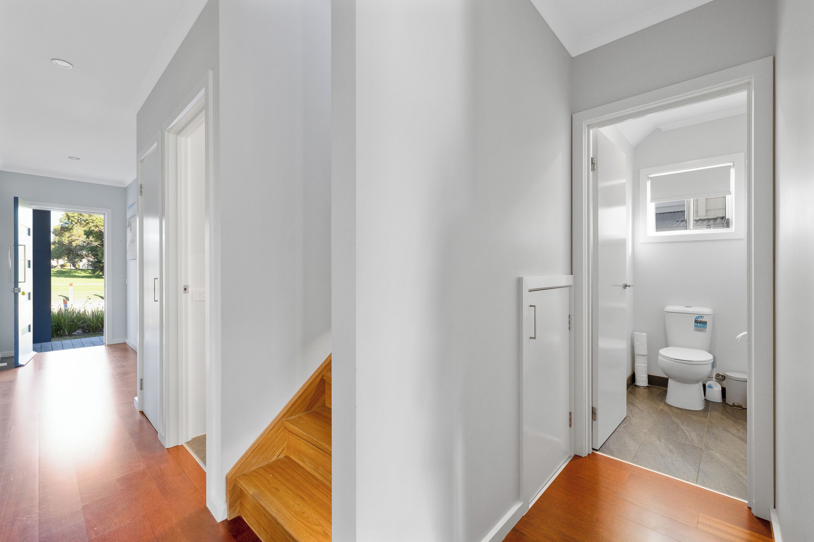 Un intérieur moderne avec un escalier en bois, des toilettes blanches et une petite fenêtre.